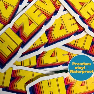 Może przedstawiać: Kolekcja naklejek ze słowem "Haze" w stylu retro. Słowo jest ż&oacute;łte z pomarańczowymi, czerwonymi i niebieskimi akcentami. Niebieskie koło z białym tekstem brzmi "Premium vinyl - Waterproof".
