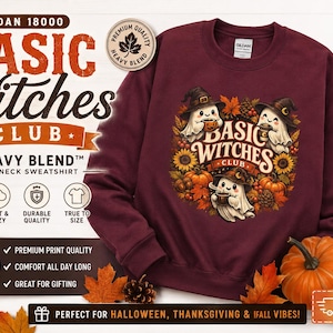 May include: A maroon crewneck sweatshirt featuring a graphic of three ghosts wearing witch hats, surrounded by pumpkins, sunflowers, and autumn leaves. The text reads Basic Witches Club. The sweatshirt is displayed with a pumpkin and fall foliage.