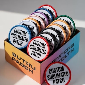 May include: A box of round, custom sublimated patches in a variety of colours, including red, blue, and green. Each patch features the text "CUSTOM SUBLIMATED PATCH" on a white background. The box has a gradient design and the text "BUTSTU PADCH".