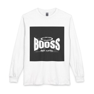 Peut inclure: T-shirt blanc à manches longues avec un motif carré noir. Le motif présente le mot "BOOSS" en blanc, surmonté d'un halo. Le texte "DREAM BIG, ACT LIKE A BOOSS" est en dessous.