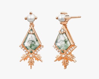 May include: A pair of rose gold earrings. Each earring features a pearlescent bead, a diamond-shaped green stone with inclusions, and a leaf-like design with small clear stones. The earrings are designed with a post-back closure.