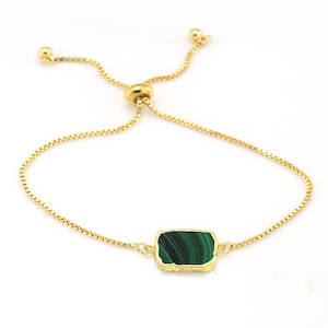 May include: A gold chain bracelet with a green malachite stone pendant. The bracelet is adjustable with a sliding knot.