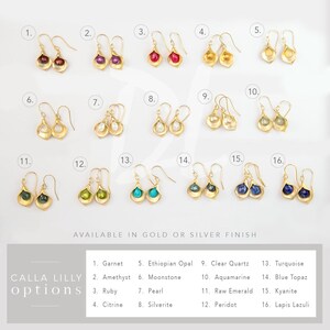 May include: A selection of 16 different gemstone earrings in a gold setting. The earrings are shaped like a flower petal. The gemstones include garnet, amethyst, ruby, citrine, Ethiopian opal, moonstone, pearl, silverite, clear quartz, aquamarine, raw emerald, peridot, turquoise, blue topaz, kyanite, and lapis lazuli.