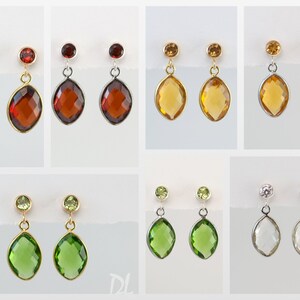 May include: A selection of gemstone earrings. Each pair has a small, round stone above a larger, teardrop-shaped stone. The earrings are set in gold, silver, and other metal tones. The gemstones are in shades of red, yellow, green, and clear.