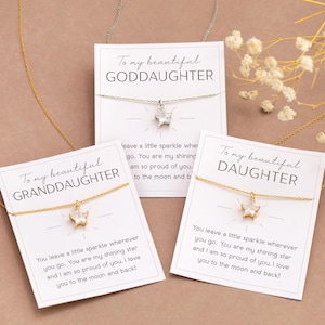Puede incluir: Tres collares con tarjetas que dicen "To my beautiful GODDAUGHTER", "GRANDDAUGHTER" y "DAUGHTER". Cada collar tiene un peque&ntilde;o colgante. Las tarjetas tienen un mensaje sobre amor y orgullo.