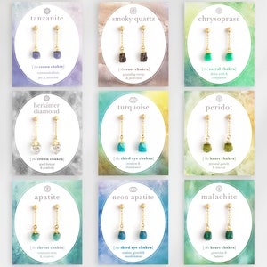 以下が含まれることがあります： 異なる色の宝石が付いた金色のイヤリングが9組。各組は、宝石の名前と対応するチャクラが書かれたカードに飾られています。宝石には、タンザナイト、スモーキークォーツ、クリソプレーズ、ヘルキマーダイヤモンド、ターコイズ、ペリドット、アパタイト、ネオンアパタイト、マラカイトが含まれています。