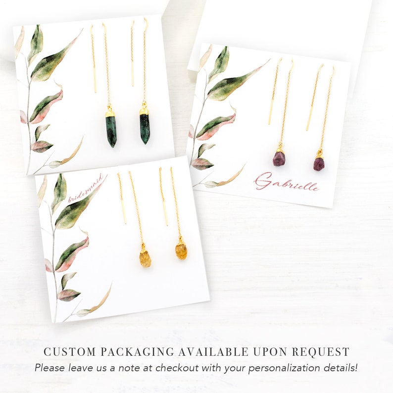 May include: Three sets of gold chain earrings with different colored gemstones. The earrings are displayed on white cards with the words "bridesmaid" and "Gabrielle" written on them.