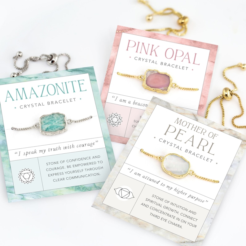 Pu&ograve; includere: Tre braccialetti di cristallo con catene dorate e ciondoli di pietre preziose. I braccialetti sono esposti su carte con i nomi "Pink Opal", "Mother of Pearl" e "Amazonite" e le loro affermazioni del chakra corrispondenti.