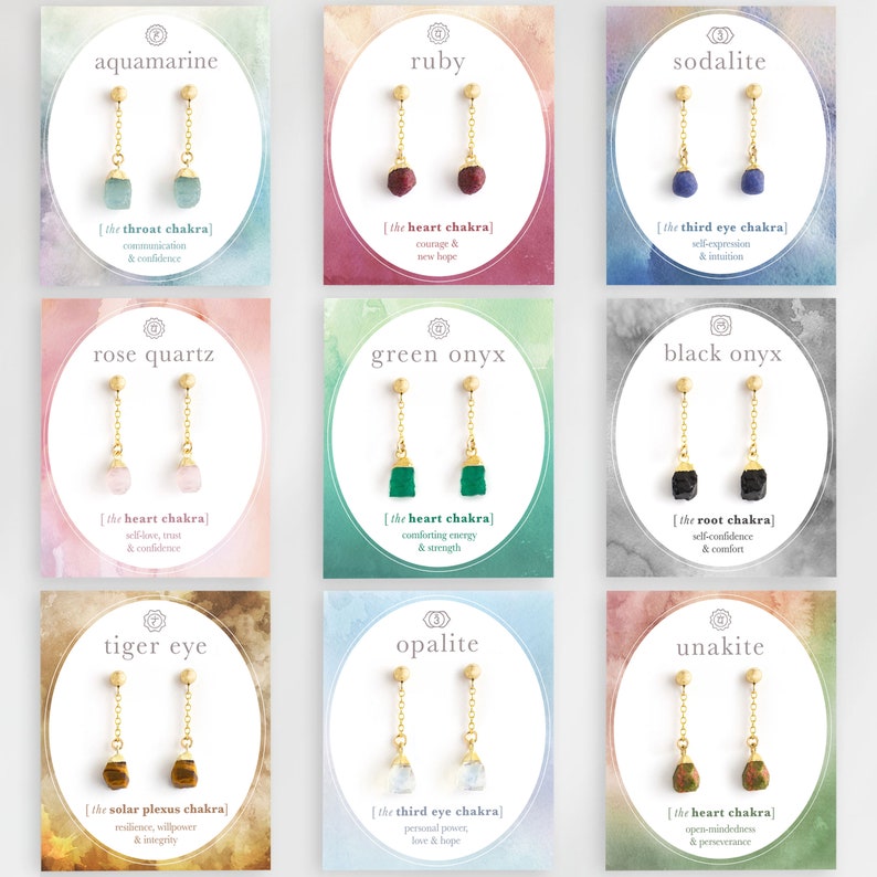 以下が含まれることがあります： 異なる色の宝石が付いた金のイヤリングが9組。各ペアは、宝石の名前と対応するチャクラが書かれたカードに表示されています。宝石はアクアマリン、ルビー、ソーダライト、ローズクォーツ、グリーンオニキス、ブラックオニキス、タイガーアイ、オパール、ウnakiteです。