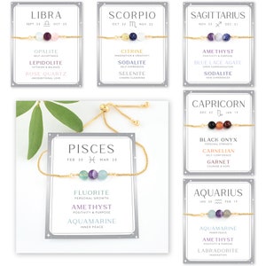 May include: A set of 12 zodiac-themed bracelets with gold chains and various gemstones. Each bracelet features a card with the zodiac sign, dates, and a list of gemstones with their corresponding meanings.