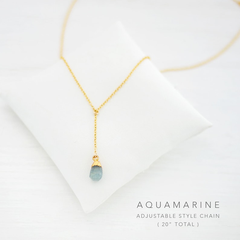 Puede incluir: Un delicado collar de cadena dorada con un colgante de piedra de aguamarina azul claro. La cadena es ajustable y mide 50,8 cm de longitud total.