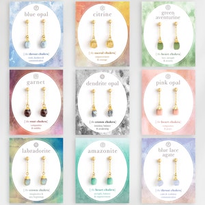 以下が含まれることがあります： 異なる色の宝石が付いた金のイヤリングが9組。各組は、宝石の名前と対応するチャクラが書かれたカードに表示されています。チャクラは、のど、仙骨、心臓、根、冠、心臓です。