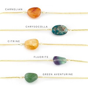 May include: Five gold chains with different colored stones attached. The stones are labeled: Carnelian, Chrysocolla, Citrine, Fluorite, and Green Aventurine.