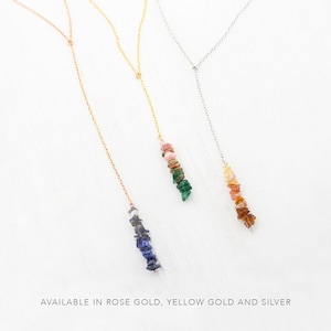 May include: Three delicate necklaces with a variety of colorful gemstone chips hanging from them. The necklaces are available in rose gold, yellow gold, and silver.