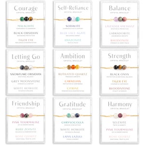 May include: Nine crystal bracelets on cards with gold chains. Each bracelet features three gemstone beads. The cards display words like "Courage," "Self-Reliance," and "Balance," along with the names and meanings of the crystals.