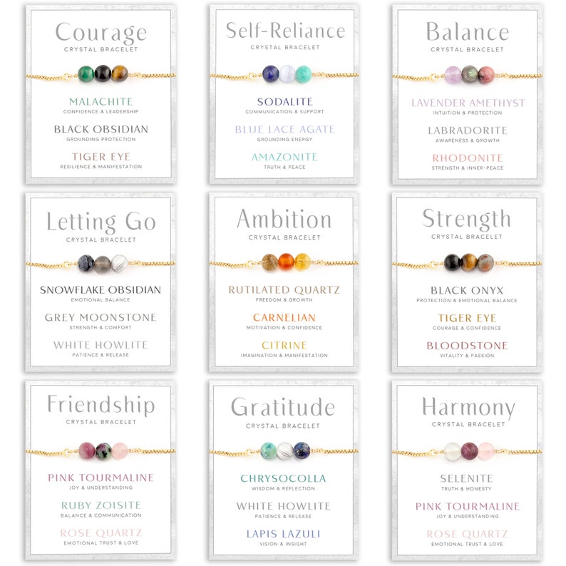 May include: Nine crystal bracelets on cards with gold chains. Each bracelet features three gemstone beads. The cards display words like "Courage," "Self-Reliance," and "Balance," along with the names and meanings of the crystals.