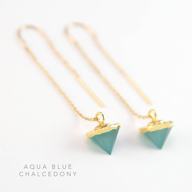 May include: A pair of gold chain earrings with aqua blue chalcedony triangle pendants. The pendants are edged in gold.