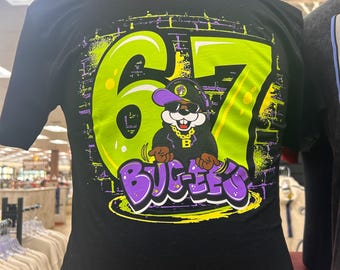 Buc-ee’s 67 Graphic T-Shirt | Neon Green & Purple Retro Design | Buc-ee’s Fan Tee | Unisex Short Sleeve Shirt