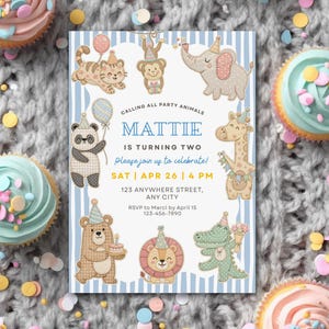 Könnte beinhalten: Eine Geburtstagseinladung mit blau-weiß gestreiftem Hintergrund, auf der Cartoon-Tiere abgebildet sind. Die Einladung lautet "Mattie wird zwei" mit Veranstaltungsdetails. Cupcakes mit bunten Streuseln umgeben die Einladung.