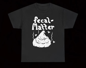 May include: Black t-shirt with the words "fecal-Matter" in white, above a white graphic of a pile of poop. The shirt has a crew neck and short sleeves. The design includes small decorative elements around the poop graphic.
