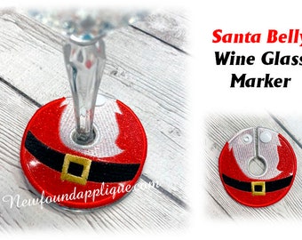 Peut inclure: Marqueur de verre à vin rouge en forme de ventre du Père Noël, avec une ceinture noire et une boucle dorée. Le texte "Santa Belly Wine Glass Marker" est visible. Le marqueur est conçu pour s'adapter à la tige d'un verre à vin.