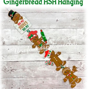 May include: A gingerbread man hanging decoration with the text "Home Sweet Home" on a sign. The decoration is made of felt and has a red, white, and green color scheme.