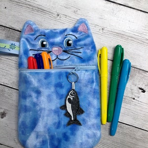 Estuche con cremallera y diseño de cara de gato con dije de pez para máquina de bordar.