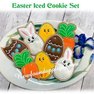 May include: A set of six Easter-themed iced cookies, including a bunny, chick, carrot, and eggs. The cookies are decorated with colourful icing and sprinkles.