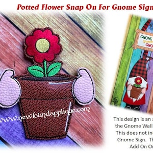 May include: A brown flower pot with a red flower and green leaves. The pot has a textured surface and is surrounded by pink fabric. The text "www.newfoundapplique.com" is visible at the bottom of the image.