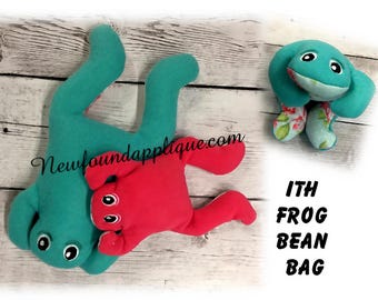 May include: Two plush frog bean bags, one teal and one red, with black eyes. The teal frog is lying on its back with its legs in the air. The red frog is lying on its stomach with its legs outstretched. The text "ITH FROG BEAN BAG" is written in black letters on a white background.