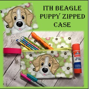 Puede incluir: Un estuche con cremallera con un diseño de cachorro beagle. El estuche es verde con flores blancas y una cremallera amarilla. El texto "ITH BEAGLE PUPPY ZIPPED CASE" está encima del estuche. Lápices, rotuladores y barra de pegamento en el interior.