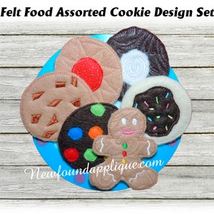 May include: Felt cookie play food set with a gingerbread man, chocolate chip, sprinkle, and other designs. The cookies are on a blue plate with a white wooden background.
