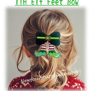 Puede incluir: Un clip para el pelo con forma de lazo de pies de elfo verde y rojo. El lazo es verde con una hebilla dorada y piernas rayadas de blanco y rojo. Los pies de elfo son verdes con una hebilla dorada.