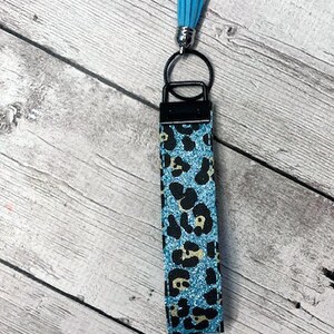 May include: A blue and black leopard print key chain with a light blue tassel.