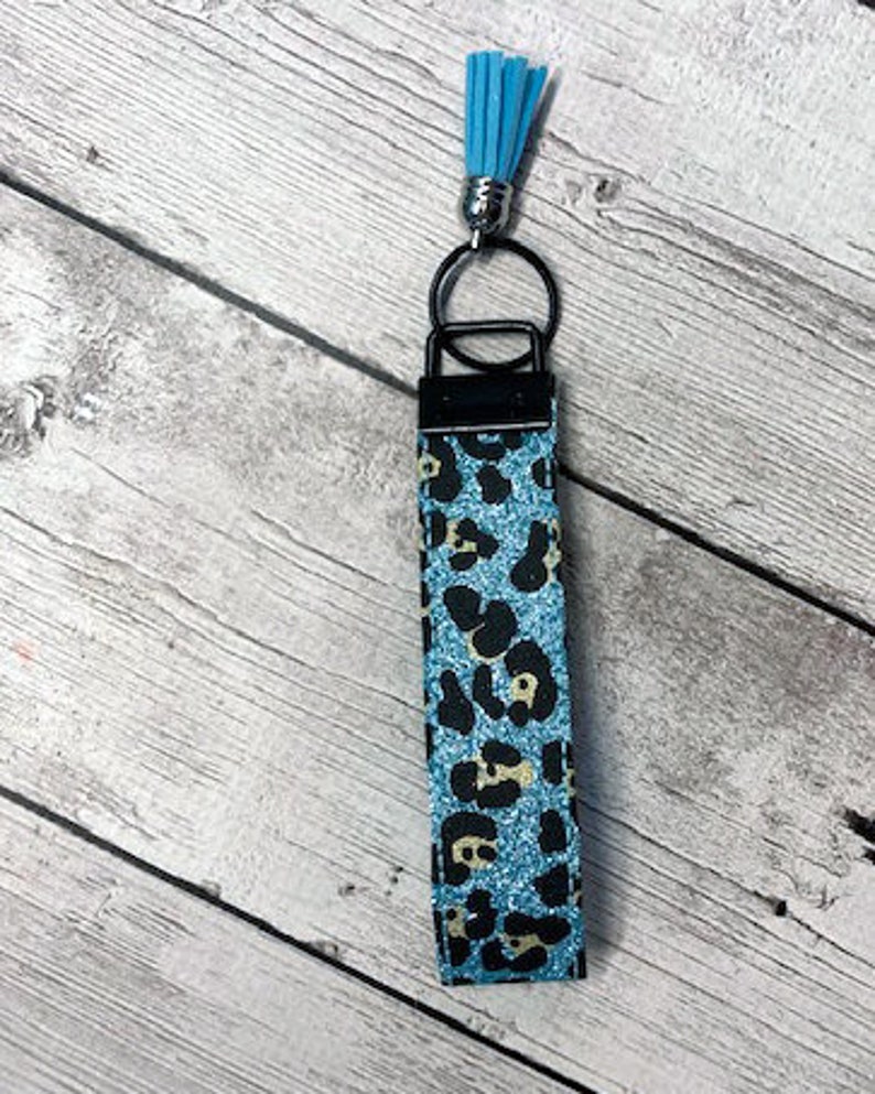 May include: A blue and black leopard print key chain with a light blue tassel.