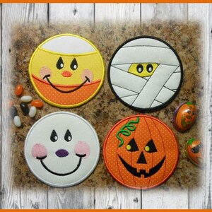 May include: Four round Halloween-themed coasters with embroidered designs. The coasters feature a smiling candy corn, a mummy, a ghost, and a jack-o'-lantern.