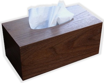 May include: A dark brown wooden tissue box with a white tissue inside.