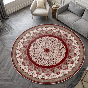 May include: A round area rug with a central medallion design. The rug features a deep red field with an intricate ivory-colored pattern. A border of beige and red frames the design, creating a decorative floor covering.
