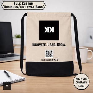 May include: A beige and black drawstring bag with the text "INNOVATE. LEAD. GROW." and a QR code. The bag has black straps and a black square with a white logo. The top banner reads "BULK CUSTOM BUSINESS/GIVEAWAY BAGS".