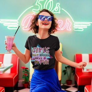 May include: A black t-shirt with a retro-style graphic that says "Girls Just Wanna 80s Have Fun". The graphic is in pink, blue, and green with a cassette tape design.