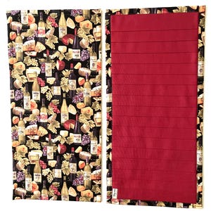 May include: A rectangular fabric organizer featuring a black background with a repeating pattern of wine bottles, grapes, and cheese wedges. The reverse side is a solid deep red fabric with horizontal stitched lines and a small white tag.
