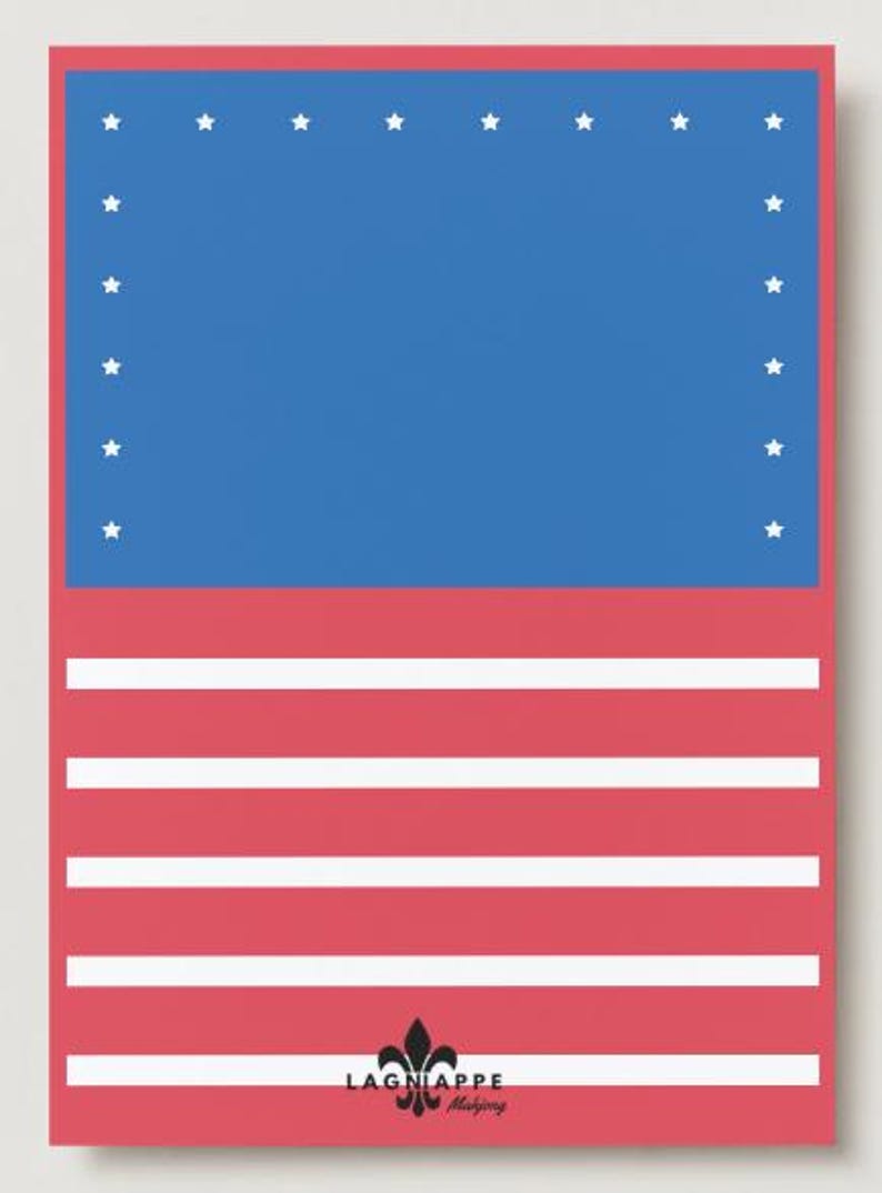May include: A patriotic design featuring a blue rectangle with white stars at the top, and red and white stripes below. The design includes the text "LAGNIAPPE Mahjong" at the bottom, with a fleur-de-lis symbol.