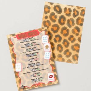 May include: Two playing cards with a leopard print background. One card features a list of Mahjong rules and card combinations. The other card has a leopard print pattern in shades of brown, orange, and black. The text on the card includes "MAHJONG WIVES".