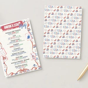 May include: Two patriotic cards with a gold pen. One card features the text "America 250th July" and contact information. The other card has a repeating pattern of "USA" with patriotic symbols in red, white, and blue.