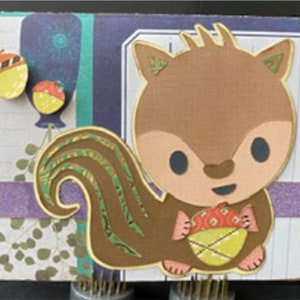 May include: A brown squirrel with a bushy tail, holding a yellow acorn. The squirrel has a cute, cartoon-like face with big eyes and a small nose. The background is a colourful patterned paper with a purple stripe.