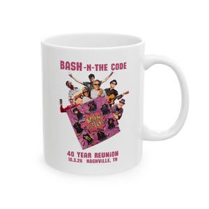 May include: A white ceramic mug featuring a graphic print with the text BASH-N-THE-CODE at the top and 40 YEAR REUNION 10.3.26 NASHVILLE, TN at the bottom. The centre shows a group of people and a purple square with the text BASH-N-THE-CODE.