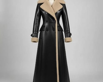 May include: A long black coat with a beige shearling collar, cuffs, and trim. The double-breasted coat features a tailored fit, two front pockets, and button closures. The coat is displayed on a mannequin.