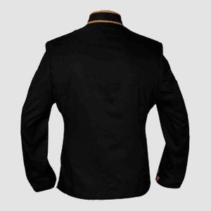 May include: A black blazer with long sleeves and a mandarin collar. The collar features a thin gold trim. The back of the jacket is visible, showcasing the tailored fit and design. The blazer is made of a smooth, dark fabric.