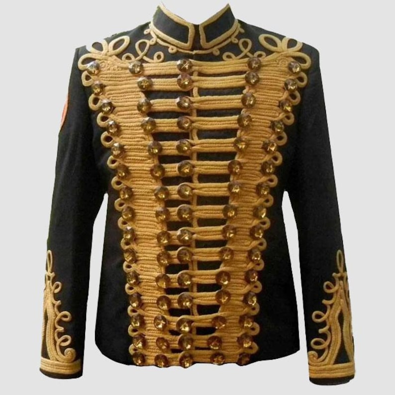 May include: Black military-style jacket with gold-colored trim and decorative buttons. The jacket features a high collar and ornate gold embroidery on the sleeves and front. A small red emblem is visible on the left sleeve.