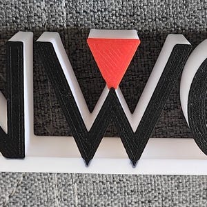 May include: A 3D sign spelling "KENWOOD" in a striking, blocky font. The letters are mainly white with black detailing, and a red triangle is integrated into the "W". This sign is probably used for branding or display.